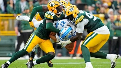 Sep 7, 2025; Green Bay, Wisconsin, USA; Green Bay Packers linebacker Edgerrin Cooper (56) and Green Bay Packers defensive tackle Colby Wooden (96) tackle an airborne Detroit Lions tight end Sam LaPorta (87) during the fourth quarter at Lambeau Field. (IMAGN IMAGES via Reuters Connect)