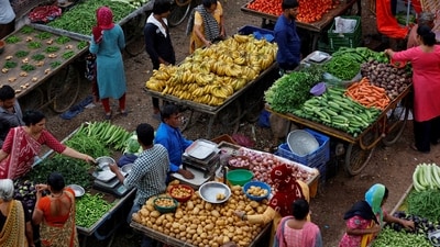 Customers buy fruit and vegetables at an open air evening market in Ahmedabad. (Reuters)