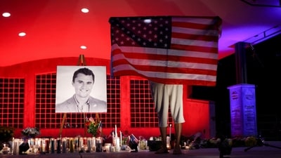 A person holds a U.S. flag during a vigil at Orem City Center Park, after U.S. right-wing activist and commentator, Charlie Kirk was fatally shot. (REUTERS)