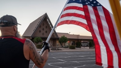 John Dickson, who says he came to "pay my respects to a great man", waves a U.S. flag outside the mortuary where the body of slain conservative activist Charlie Kirk was delivered to, in Phoenix, Arizona, U.S., September 11, 2025, one day after Kirk was fatally shot during an event at Utah Valley University. REUTERS/Thomas Machowicz (REUTERS)
