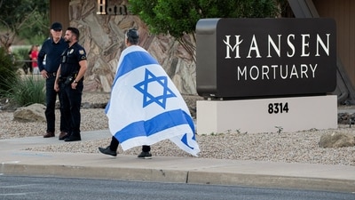 A man, wearing an Israeli flag over his shoulders, walks outside the mortuary where the body of slain conservative activist Charlie Kirk was delivered to, in Phoenix, Arizona, U.S., September 11, 2025, one day after Kirk was fatally shot during an event at Utah Valley University. REUTERS/Thomas Machowicz (REUTERS)
