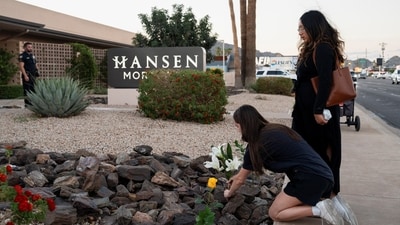 A woman places flowers at a makeshift memorial outside the mortuary where the body of slain conservative activist Charlie Kirk was delivered (Reuters)