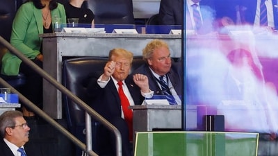 Donald Trump, in his signature suit and tie, was seated next to Yankees team president Randy Levine and chatted with him throughout the game. (AFP) Donald Trump, in his signature suit and tie, was seated next to Yankees team president Randy Levine and chatted with him throughout the game. (AFP)