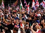 Supporters of British far-right activist Tommy Robinson, whose real name is Stephen Yaxley-Lennon, walk with Union flags and St George's cross and Welsh flags and Christian crosses through central London during a 'Free speech' march, on September 13, 2025. 