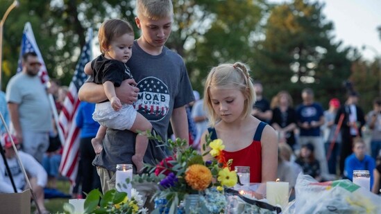 Children place a candle at a makeshift memorial during a candlelight vigil for right-wing activist Charlie Kirk at Memorial Park in Provo, Utah, on September 12, 2025, after he was shot during a public event at Utah Valley University. &nbsp;(Photo by Melissa MAJCHRZAK / AFP)(AFP)