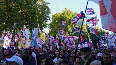 People showed up with flags and banners for anti-immigration protest led by 42-year-old Tommy Robinson (AP) People showed up with flags and banners for anti-immigration protest led by 42-year-old Tommy Robinson (AP)