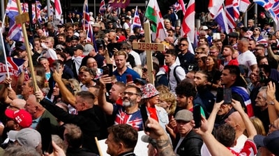 Supporters of British far-right activist Tommy Robinson, whose real name is Stephen Yaxley-Lennon, walk with Union flags and St George's cross and Welsh flags through central London during a 'Free speech' march. (AFP) Supporters of British far-right activist Tommy Robinson, whose real name is Stephen Yaxley-Lennon, walk with Union flags and St George's cross and Welsh flags through central London during a 'Free speech' march. (AFP)