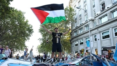 A pro-Palestinian protestor waves a Palestinian flag after the protestors invaded the street during the 21st and last stage of the Vuelta a España 2025, near Atocha station in Madrid, on September 14, 2025. The Vuelta final stage has been abandoned because of pro-Palestinian protests. (AFP) A pro-Palestinian protestor waves a Palestinian flag after the protestors invaded the street during the 21st and last stage of the Vuelta a España 2025, near Atocha station in Madrid, on September 14, 2025. The Vuelta final stage has been abandoned because of pro-Palestinian protests. (AFP)