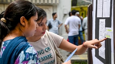 Candidates check a notice board for their allotted seats as they arrive to appear for the West Bengal School Service Commission (WBSSC) State Level Selection Test (SLST) for teachers' recruitment, at an examination centre, in Kolkata on Sunday. (PTI) Candidates check a notice board for their allotted seats as they arrive to appear for the West Bengal School Service Commission (WBSSC) State Level Selection Test (SLST) for teachers' recruitment, at an examination centre, in Kolkata on Sunday. (PTI)