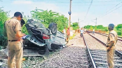 Police at the spot where the car fell, on a railway track below Mukarba Chowk flyover. (ANI) Police at the spot where the car fell, on a railway track below Mukarba Chowk flyover. (ANI)