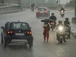 Commuters wade through a waterlogged street following heavy rains in Ajmer, Rajasthan, on September 4.