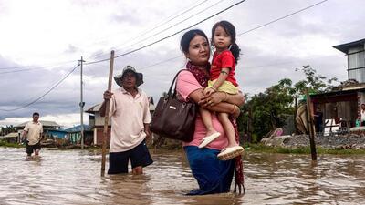 Locals wade through a flooded street after heavy monsoon rain showers in Imphal East, in India's Manipur on September 14. (AFP) Locals wade through a flooded street after heavy monsoon rain showers in Imphal East, in India's Manipur on September 14. (AFP)