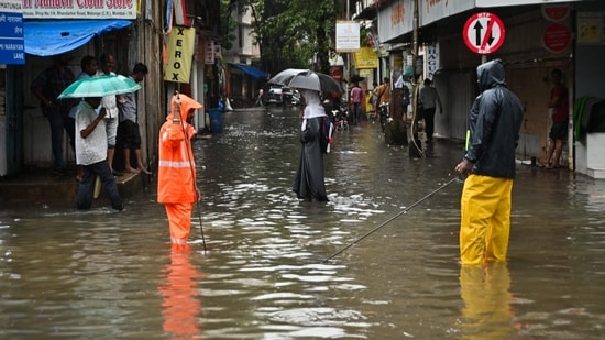 People wading through knee deep water at Bhandarkar road in Mumbai's Matunga areas(Raju Shinde/Hindustan Times)