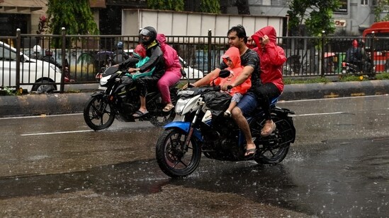 Mumbai woke up to a heavy rainfall on Monday morning and commutors were seen travelling in raincoat through the downpour(Raju Shinde/Hindustan Times)