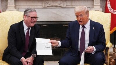 British Prime Minister Keir Starmer hands an invitation from King Charles III to US President Donald Trump at the White House. (AP) British Prime Minister Keir Starmer hands an invitation from King Charles III to US President Donald Trump at the White House. (AP)