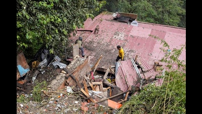 Residents inspect a house, damaged in a landslide following heavy rainfall, in Shimla, Himachal Pradesh, on Tuesday. (PTI)