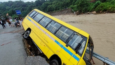 A school bus of Doon Valley Public School is stuck on a damaged road after heavy rain triggered a cloudburst in Dehradun. (PTI) A school bus of Doon Valley Public School is stuck on a damaged road after heavy rain triggered a cloudburst in Dehradun. (PTI)