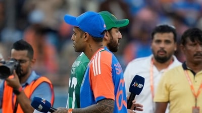 Pakistan's captain Salman Agha, rear, walks past India's captain Suryakumar Yadav after the coin toss (AP) Pakistan's captain Salman Agha, rear, walks past India's captain Suryakumar Yadav after the coin toss (AP)