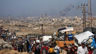 Displaced Palestinians move with their belongings southwards on a road in the Nuseirat refugee camp in the central Gaza Strip as smoke billows during Israeli strikes in Gaza City. (Eyad Baba/AFP) Displaced Palestinians move with their belongings southwards on a road in the Nuseirat refugee camp in the central Gaza Strip as smoke billows during Israeli strikes in Gaza City. (Eyad Baba/AFP)