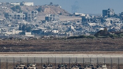 Tanks stand on the Israeli side of the border, as destruction in Gaza is seen in the background, in Israel. (Amir Cohen/Reuters)
