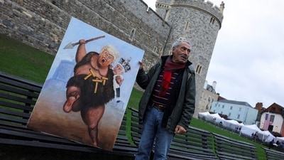 Artist Kaya Mar holds a painting depicting a caricature of U.S. President Donald Trump and Britain's King Charles, outside of the Windsor Castle, on the day of the state visit of U.S. President Donald Trump and first lady Melania Trump to Britain, in Windsor, Britain, September 17, 2025. REUTERS/Toby Melville (REUTERS)