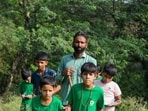 Sunil Harsana explaining trees and butterflies to children at Mangar Bani near Godaria Baba Mandir on Thursday. (Parveen Kumar/HT) Sunil Harsana explaining trees and butterflies to children at Mangar Bani near Godaria Baba Mandir on Thursday. (Parveen Kumar/HT)