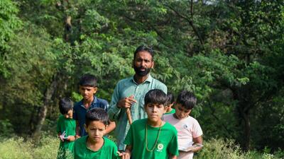 Sunil Harsana explaining trees and butterflies to children at Mangar Bani near Godaria Baba Mandir on Thursday. (Parveen Kumar/HT) Sunil Harsana explaining trees and butterflies to children at Mangar Bani near Godaria Baba Mandir on Thursday. (Parveen Kumar/HT)