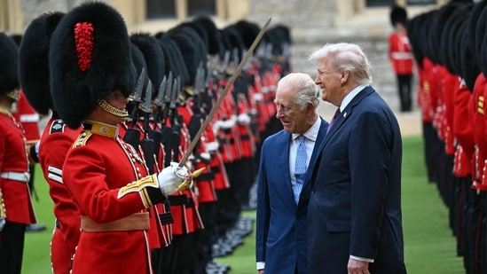 Britain's King Charles III (C) and US President Donald Trump (R) talk with a Coldstream Guardsman as they inspect the guard of honour during a ceremonial welcome in the Quadrangle at Windsor Castle, in Windsor, on September 17, 2025, during the US president's second State Visit. (AFP)