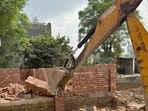 A bulldozer deployed at the demolition site in Mundian Kalan in Ludhiana on Friday. (HT Photo)