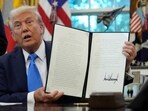 U.S. President Donald Trump displays a signed executive order on gold card visa in the Oval Office at the White House in Washington, D.C