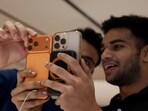 A customer compares his old iPhone with the newly launched iPhone 17 pro max at an Apple retail store 