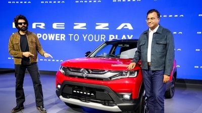Bollywood actor Kartik Aaryan, left, poses for photographs next to a Brezza model at the Maruti stall during Bharat Mobility Global Expo 2025, in New Delhi. (PTI) Bollywood actor Kartik Aaryan, left, poses for photographs next to a Brezza model at the Maruti stall during Bharat Mobility Global Expo 2025, in New Delhi. (PTI)