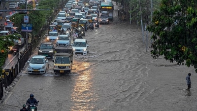 Hyderabad commuters make their way through a waterlogged road following rainfall. (PTI) Hyderabad commuters make their way through a waterlogged road following rainfall. (PTI)