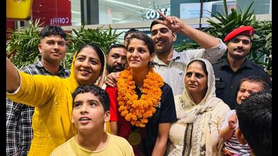 Jaismine Lamboria with her family at the airport after returning from Liverpool. (HT Photo)