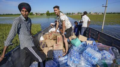 Volunteers on their way to assist in distribution of relief material in flood-affected areas, at Talwandi Rai Dadu village of Ajnala, in Amritsar district. (PTI FILE)