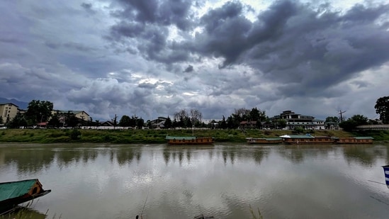 A man fishes in the Jhelum river as clouds cover the skyline, in Srinagar. (PRI)