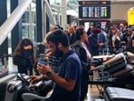 Travellers wait near check-in desks at Heathrow Airport Terminal 2 amid flight delays and cancellations resulting from a disruption to check-in and boarding systems caused by a cyberattack that has affected several major European airports.