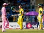 Australia's Beth Mooney, back left, celebrates her century with Ashleigh Gardner, right.