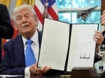 U.S. President Donald Trump displays a signed executive order on gold card visa in the Oval Office at the White House in Washington, D.C., U.S., September 19, 2025. REUTERS/Ken Cedeno     TPX IMAGES OF THE DAY