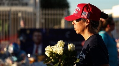 A woman brings flowers to a makeshift memorial for right-wing activist and Turning Point USA founder Charlie Kirk outside of their headquarters in Phoenix, Arizona, on September 19, 2025. (AFP) A woman brings flowers to a makeshift memorial for right-wing activist and Turning Point USA founder Charlie Kirk outside of their headquarters in Phoenix, Arizona, on September 19, 2025. (AFP)