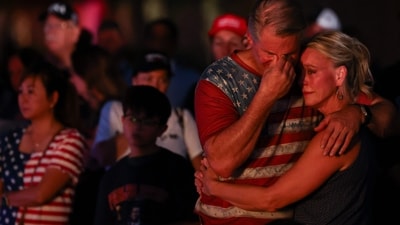 People embrace and mourn at a makeshift memorial during a vigil for right-wing activist and Turning Point USA founder Charlie Kirk outside their headquarters in Phoenix, Arizona on September 19, 2025. (AFP) People embrace and mourn at a makeshift memorial during a vigil for right-wing activist and Turning Point USA founder Charlie Kirk outside their headquarters in Phoenix, Arizona on September 19, 2025. (AFP)