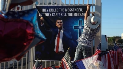Dr. T Tran places a poster up in the makeshift memorial for Charlie Kirk outside the headquarters of Turning Point USA on September 19, 2025, in Phoenix, Arizona. Kirk, the CEO and co-founder of Turning Point USA, was shot and killed on September 10th while speaking at an event for his "American Comeback Tour" at Utah Valley University. A memorial service for him, open to the public, is planned for Sunday at the State Farm Stadium and will begin at 11 a.m., with President Donald Trump scheduled to attend. Joe Raedle/Getty Images/AFP (Photo by JOE RAEDLE / GETTY IMAGES NORTH AMERICA / Getty Images via AFP) (Getty Images via AFP) Dr. T Tran places a poster up in the makeshift memorial for Charlie Kirk outside the headquarters of Turning Point USA on September 19, 2025, in Phoenix, Arizona. Kirk, the CEO and co-founder of Turning Point USA, was shot and killed on September 10th while speaking at an event for his "American Comeback Tour" at Utah Valley University. A memorial service for him, open to the public, is planned for Sunday at the State Farm Stadium and will begin at 11 a.m., with President Donald Trump scheduled to attend. Joe Raedle/Getty Images/AFP (Photo by JOE RAEDLE / GETTY IMAGES NORTH AMERICA / Getty Images via AFP) (Getty Images via AFP)