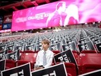 A young attendee sits in the stands ahead of the memorial service for political activist Charlie Kirk 