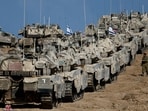 An Israeli soldier walks next to military vehicles near the border with Gaza, in Israel September 17, 2025.