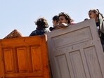 A displaced Palestinian girl, part of many fleeing northern Gaza due to an Israeli military operation, on a vehicle carrying wooden doors and other items, after Israeli forces ordered residents of Gaza City to evacuate to the south, in the central Gaza Strip, September 21, 2025.