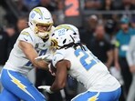 Los Angeles Chargers quarterback Justin Herbert (10) hands the ball off to Najee Harris (22)