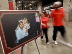 Charlie Kirk memorial: People walk past a picture of slain conservative commentator Charlie Kirk and his wife Erika at State Farm Stadium, on the day of his memorial service, in Glendale, Arizona, U.S., September 21, 2025.  REUTERS/Carlos Barria