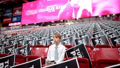 A young attendee sits in the stands ahead of the memorial service for political activist Charlie Kirk (Getty Images via AFP) A young attendee sits in the stands ahead of the memorial service for political activist Charlie Kirk (Getty Images via AFP)