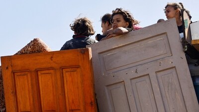 A displaced Palestinian girl, part of many fleeing northern Gaza due to an Israeli military operation, on a vehicle carrying wooden doors and other items, after Israeli forces ordered residents of Gaza City to evacuate to the south, in the central Gaza Strip, September 21, 2025. (Mahmoud Issa/Reuters)