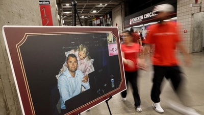 Charlie Kirk memorial: People walk past a picture of slain conservative commentator Charlie Kirk and his wife Erika at State Farm Stadium, on the day of his memorial service, in Glendale, Arizona, U.S., September 21, 2025.  REUTERS/Carlos Barria (REUTERS)
